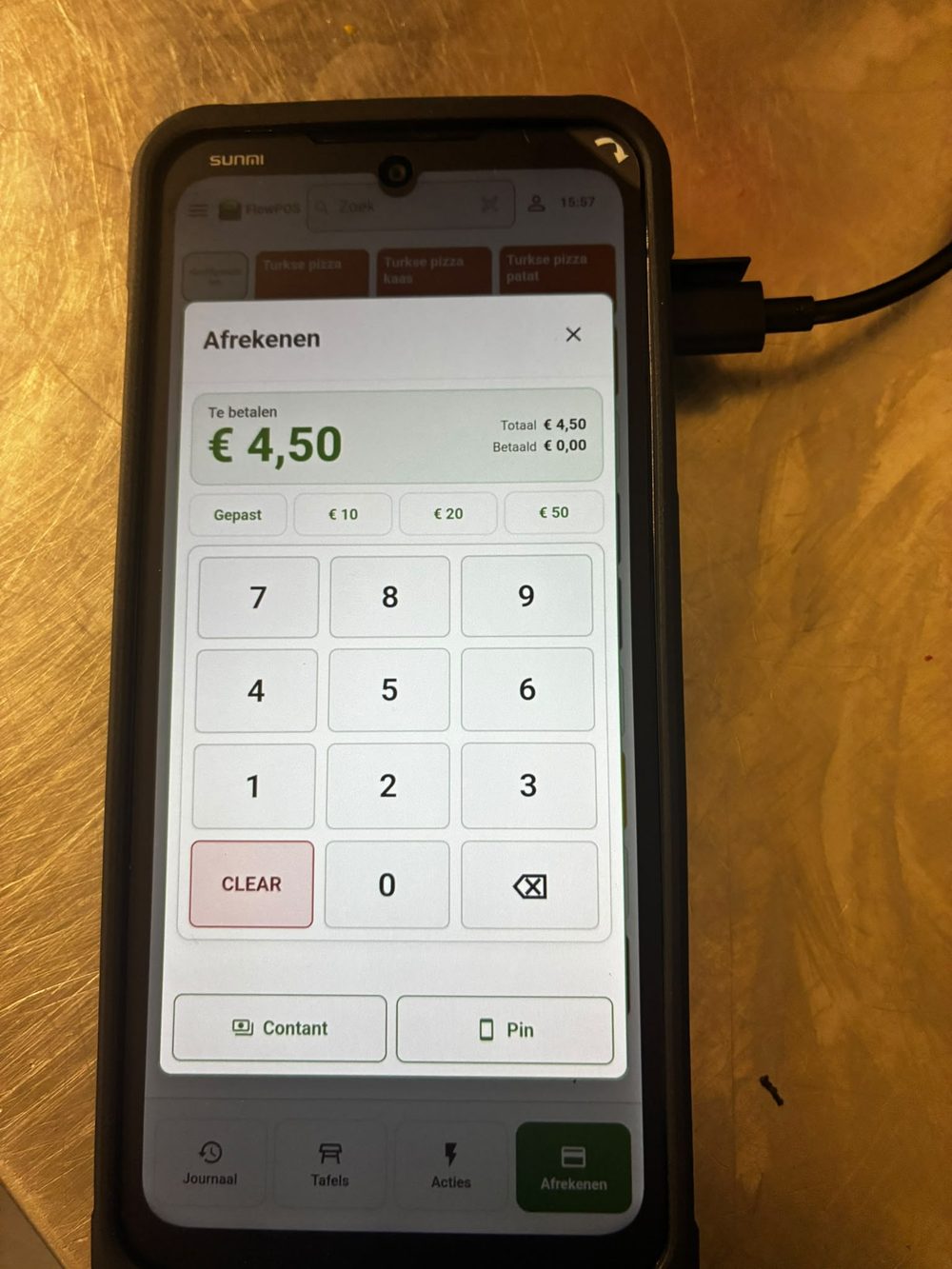 Een Sunmi-handheld bij Garfield Doner met het afrekenscherm van FlowPOS open: te betalen € 4,50, met knoppen voor contant en pin.